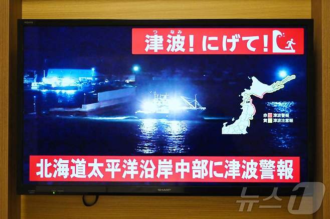 일본 동북부 아오모리현 동쪽 해상에서 8일 밤 11시 15분쯤 규모 7.6의 지진이 발생, 쓰나미 경보가 내렸다. TV에 일본 북부 홋카이도 삿포로의 한 해안 항구를 떠나는 배의 실시간 영상이 나오고 있다. ⓒ AFP=뉴스1