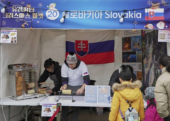슬로바키아 굴뚝 빵 만드는 모습을 관람객이 지켜보고 있다. 성북구청 제공