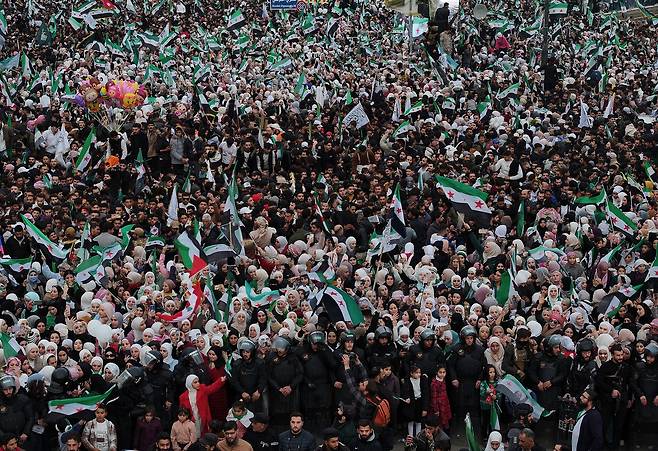 8일(현지시간) 시리아 다마스쿠스의 우마이야 광장에서 시민 수만명이 바샤르 알아사드 전 대통령 축출 1주년을 기념하는 행사에 모여 있다. AP연합뉴스