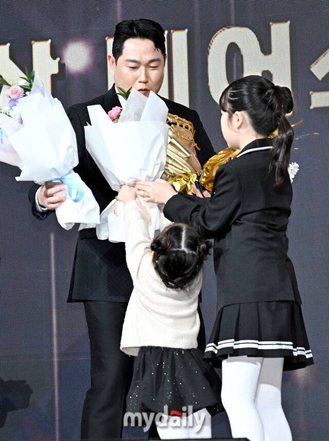 두산 양의지가 9일 오후 서울 잠실 롯데호텔에서 진행된 '2025 KBO 골든글러브 시상식' 에서 포수 부문 골든글러브상을 수상한 뒤 딸에게 꽃다발을 받고 있다. 포지션별 최고 선수를 가리는 '2025 KBO 골든글러브 시상식'은 투수와 포수, 지명타자, 1루수, 2루수, 3루수, 유격수, 외야수(3명) 등 총 10개 부문에 걸쳐 최고의 선수를 가린다./잠실 = 송일섭 기자