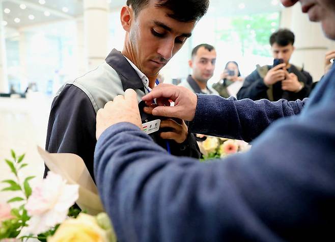 [서울=뉴시스] 22일 인천국제공항에서 타지키스탄 고용허가제 외국인근로자(E-9)의 최초 입국을 기념해 직접 지은 한글 이름표 달아주기 행사가 열리고 있다.(사진=한국산업인력공단 제공) 2025.10.22. photo@newsis.com *재판매 및 DB 금지