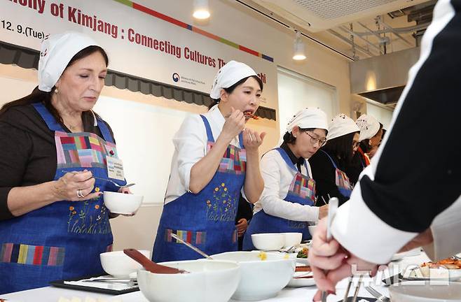 [서울=뉴시스] 고범준 기자 = 김혜경 여사가 9일 서울 종로구 북촌 한식문화공간 이음에서 열린 주한대사 배우자 초청 김장 행사에서 김치를 시식하고 있다. 2025.12.09. bjko@newsis.com