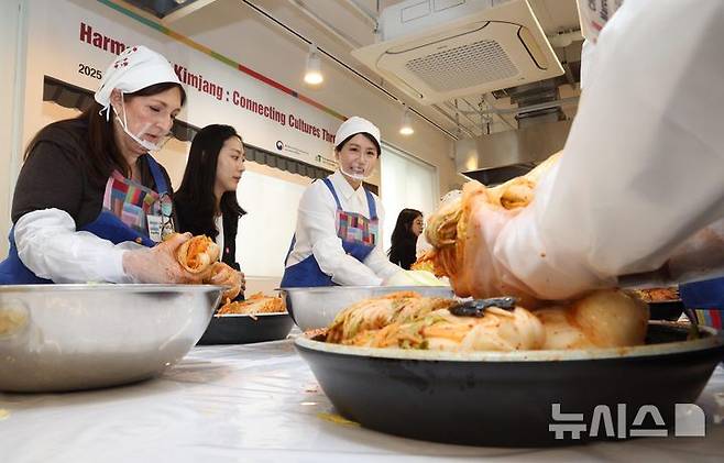 [서울=뉴시스] 고범준 기자 = 김혜경 여사가 9일 서울 종로구 북촌 한식문화공간 이음에서 열린 주한대사 배우자 초청 김장 행사에서 주한 외국대사 배우자들과 함께 김치를 담그고 있다. 2025.12.09. bjko@newsis.com