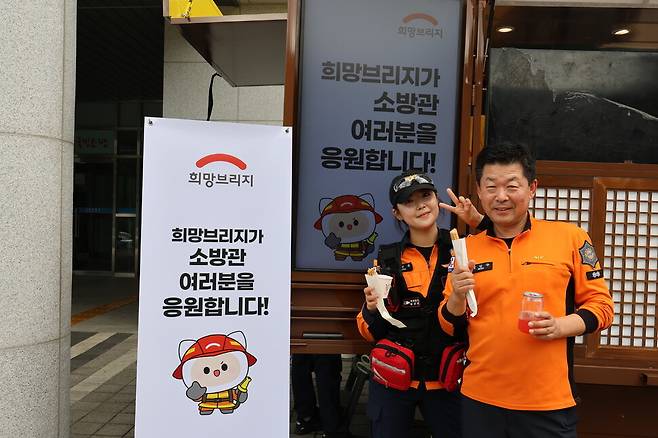 희망브리지는 소방청과 함께 재난 대응 소방관 긴급 지원 프로세스를 운영하고 있다. 장시간 구조작업과 훈련에 참여하는 소방관들의 체력 회복을 위해 지원한 간식을 먹고 있는 정은옥·정인수 부녀 소방관. 희망브리지 전국재해구호협회 제공