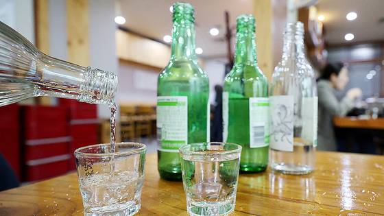Soju glasses are filled with liquor in a restaurant in Seoul in May last year. [NEWS1]