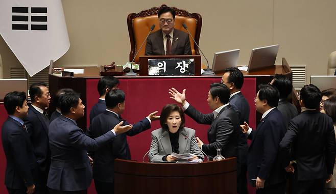 12월9일 국회 본회의에서 나경원 국민의힘 의원(가운데 아래)이 '가맹사업거래의 공정화에 관한 법률 일부개정법률안'에 대해 무제한 토론하는 가운데 여야 의원들이 발언대에서 목소리를 높이며 신경전을 이어가고 있다. ⓒ연합뉴스
