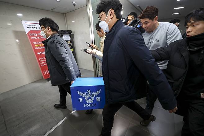Police officials are seen transporting material found during a raid on e-commerce giant Coupang's headquarters in Songpa District, southern Seoul on Dec. 9. [JOINT PRESS CORPS]
