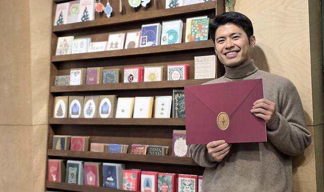 김승호 대표가 9일 서울 마포구 팔시보스토어에서 커다란 편지를 들고 웃고 있다.