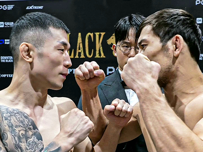 제3대 블랙컴뱃 밴텀급 챔피언 ‘투신’ 김재웅이 2025년 8월 인천광역시 영종국제도시 인스파이어 아레나 페더급 메인이벤트 계체에 실패한 ‘울프킹’ 아딜레트 누르마토프와 대결에 동의한 후 마주 보고 있다. 가운데는 김경원 실장 겸 링아나운서. 사진=이데아 파라곤