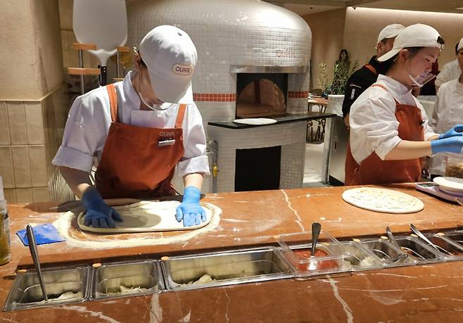 올리페페 매장 한가운데 위치한 공간에서는 주문 즉시 화덕피자를 빚어 화덕에 굽는 모습을 볼 수 있다./사진제공=CJ푸드빌