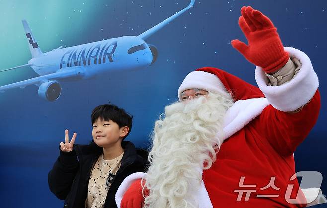 한국을 찾은 핀란드 공인 산타클로스가 14일 서울 중구 남산타워 앞에서 아이와 기념촬영을 하고 있다. 2025.12.14/뉴스1 ⓒ News1 이호윤 기자