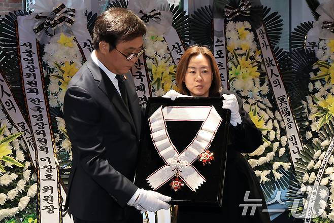 최휘영 문화체육관광부 장관이 14일 서울 중구 서울영화센터에 마련된 고 김지미 배우의 추모공간을 찾아 금관문화훈장을 전달하고 있다. 2025.12.14/뉴스1 ⓒ News1 이호윤 기자