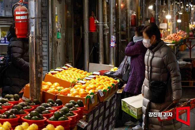 서울 동대문구 청량리청과물시장을 찾은 고객이 상인에게 귤 가격을 물어보고 있다. 강진형 기자