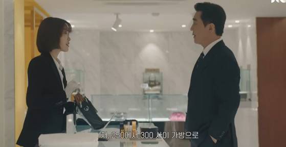 JTBC 드라마 '서울 자가에 대기업 다니는 김부장 이야기' 속 김 부장은 상무와 대리가 든 명품 가방을 보고 그 사이 가격대의 가방을 사러 간다. 사진 JTBC 드라마 유튜브 갈무리