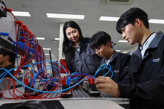 지난달 17일 경기 수원 수원하이텍고에서 3학년 전은지(자동화시스템과, 가장 왼쪽), 이호왕(정밀기계과), 강희준(전기전자제어과) 학생이 자동제어시스템(PLC) 설비를 이용해 반도체 생산 분야에서 활용되는 자동화 설비 공정이 작동되는 원리를 배우고 있다. 김종호 기자