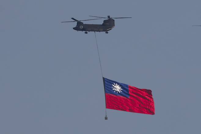 A CH-47SD Chinook transport helicopter hoists a giant Taiwan flag on Oct. 8 as it flies over downtown Taipei during a flag flyby rehearsal ahead of the country’s National Day, in Taipei, Taiwan. [EPA/YONHAP]