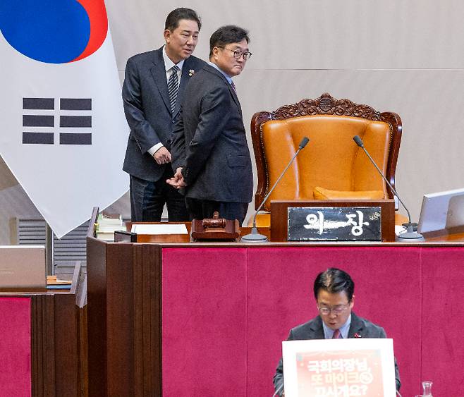 우원식 국회의장과 더불어민주당 김병기 원내대표가 11일 국회에서 열린 12월 임시국회 1차 본회의에서 국민의힘 곽규택 의원이 형사소송법 일부개정법률안에 대한 무제한 토론(필리버스터)에 손팻말을 이용하는 것에 대해 의견을 나누고 있다. 연합뉴스