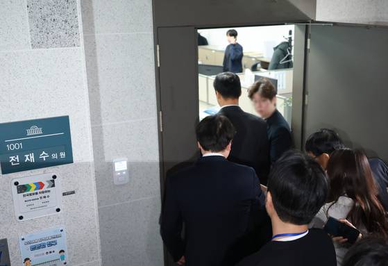 정치권 인사들의 통일교 금품 수수 의혹과 관련해 첫 강제수사에 착수한 15일 경찰 관계자들이 서울 여의도 국회 의원회관 내 전재수 더불어민주당 의원 사무실로 들어가고 있다. 연합뉴스