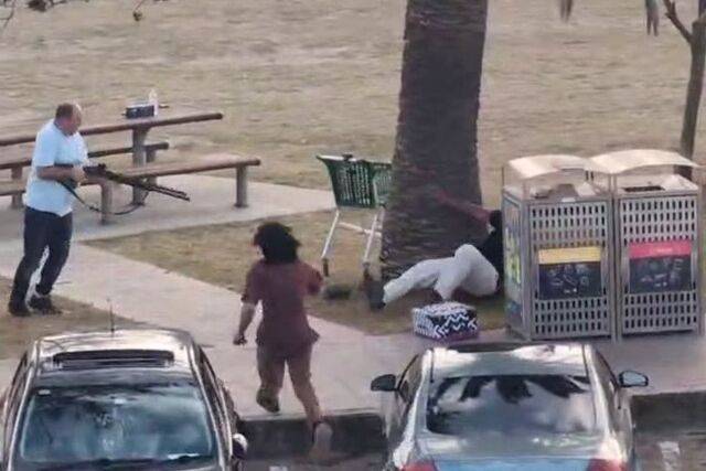 14일(현지시간) 호주 시드니 본다이 해변에서 총격범을 제압한 시민(왼쪽)이 빼앗은 총으로 쓰러진 총격범을 겨누고 있다. 호주 ABC방송 캡처