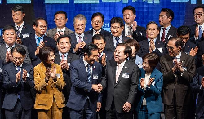 정청래 더불어민주당 대표(앞줄 왼쪽 셋째)와 김기문 중소기업중앙회 회장(앞줄 왼쪽 넷째)이 15일 서울 여의도 중소기업중앙회에서 민주당과 중기중앙회가 공동 개최한 '중소기업 입법 과제 타운홀미팅'에서 만나 악수하고 있다.  연합뉴스