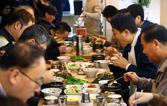 오세훈 서울시장이 16일 서울 용산구의 '희망의 인문학' 수료생들이 직접 운영하는 동행스토어 1호점 집밥 음식점 '정담(情談)' 을 찾아 참석자들과 식사를 하고 있다. 뉴스1
