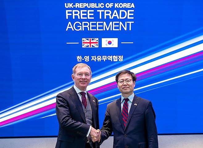 South Korean Trade Minister Yeo Han-koo (right) and UK Trade Minister Chris Bryant pose after signing an upgraded bilateral free trade agreement in London on Monday. (Trade Ministry)
