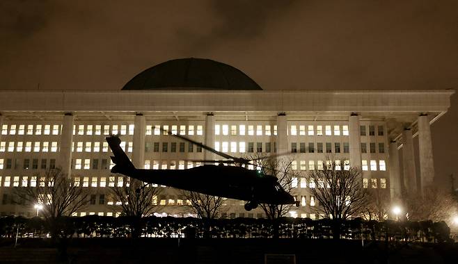 A helicopter carrying martial law troops lands at the grounds of the National Assembly in Yeouido, western Seoul, in the early hours of Dec. 4, 2024, after then President Yoon Suk Yeol declared emergency martial law in a late-night televised address to the nation on Dec. 3, 2024. [JEON MIN-GYU]