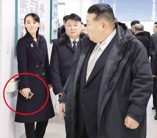 김여정 손에 ‘폴더블 스마트폰’… 대북제재 뚫었나 - 지난 14일 북한 조선중앙통신이 공개한 평안북도 구성시병원 준공식 사진에서 김여정(맨 왼쪽) 노동당 부부장이 중국 브랜드 아너의 ‘매직’ 시리즈로 추정되는 폴더블 스마트폰(붉은 원 안)을 손에 쥐고 있다. 유엔 안전보장이사회 대북제재 결의 2397호는 전자기기의 북한 수출입을 금지하고 있다. 평양 조선중앙통신· 연합뉴스