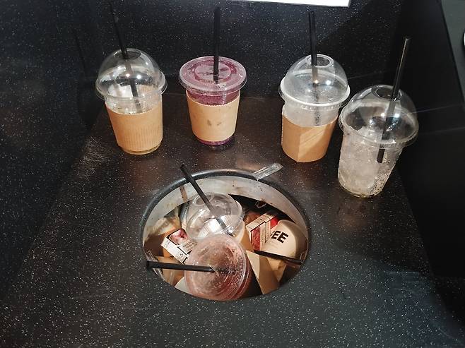 Empty plastic cups pile up inside a cafe in Jung District, central Seoul. [JOONGANG ILBO]