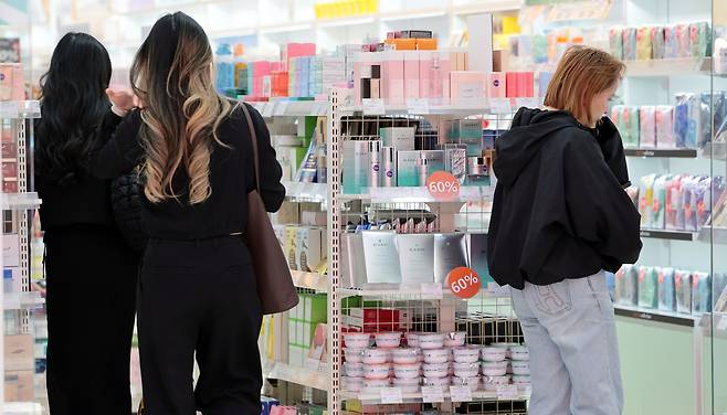 서울 중구 명동의 한 화장품 가게에서 외국인 관광객들이 뷰티 용품을 고르고 있다. [연합]