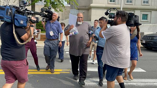 2023년 6월 14일 미국 뉴햄프셔주 콘코드의 연방 법원 앞에서, 기증 시신 불법 거래 혐의로 체포된 세드릭 로지가 얼굴을 가린 채 법원을 나서고 있다. 게티이미지