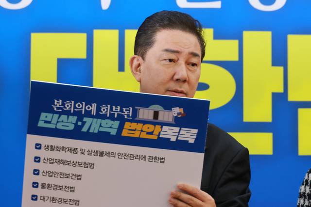 김병기 더불어민주당 원내대표가 18일 여의도 국회에서 열린 정책조정회의에 참석해 민생 개혁 법안 목록이 적힌 손팻말을 들고 있다. [연합뉴스]