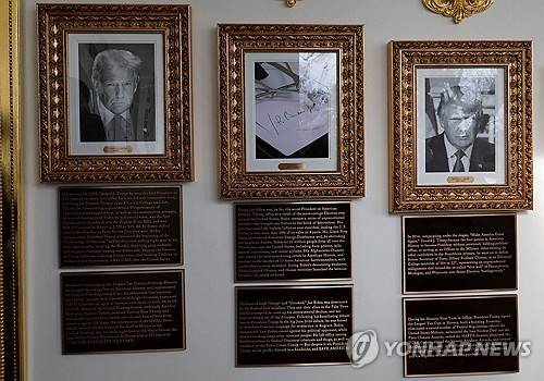 백악관에 걸린 역대 대통령 사진과 새로 설치된 동판 [로이터=연합뉴스 제공]