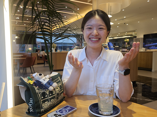 TK장녀로 유명해진 금희정씨가 지난 19일 대구 북구의 한 카페에서 영남일보 인터뷰에 응하고 있다. 금씨가 소지한 휴대전화와 가방 등엔 이재명 대통령과 더불어민주당을 지지한다는 의미를 담은 굿즈들이 달려있다. 서민지기자 mjs858@yeongnam.com