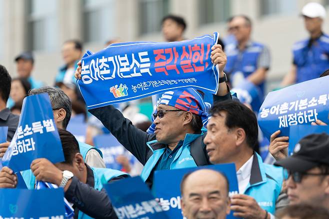 지난 9월 12일 서울 여의도 국회에서 열린 '농어촌기본소득 입법 촉구 500인 기자회견'에서 참가자들이 농어촌 기본소득법 제정을 촉구하고 있다. 농어촌기본소득 법안은 농어촌 읍·면 지역에 1년 이상 거주한 모든 주민에게 월 30만원(연 360만원) 수준의 기본소득을 단계적으로 확대 지급하는 것을 골자로 한다. /뉴스1