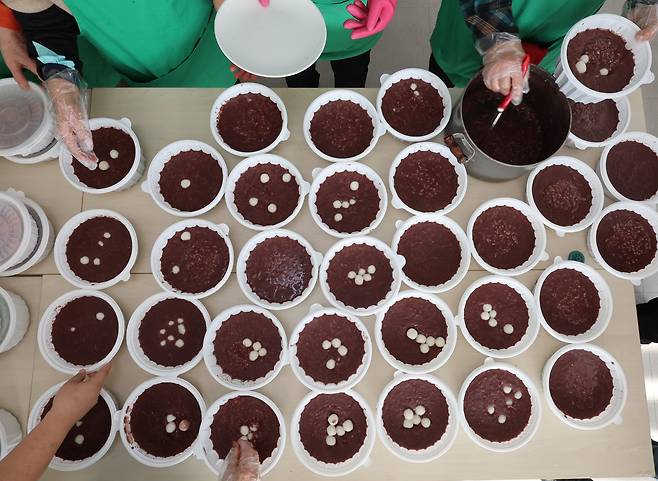 동지를 앞둔 18일 인천 미추홀구 용현1동4동 행정복지센터에서 새마을부녀회원들이 취약계층 어르신들에게 전달할 동지팥죽을 포장하고 있다. /뉴시스