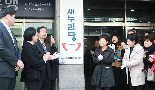 2012년 2월 16일 새누리당 당시 박근혜 비상대책위원장이 서울 영등포구 여의도 새누리 당사에서 열린 새누리당 현판식에서 당명 제안자인 김성준, 최유경 씨등과  함께 새당명이 새겨진 현판을 당사 외부 벽에 걸고 있다. 동아일보 DB