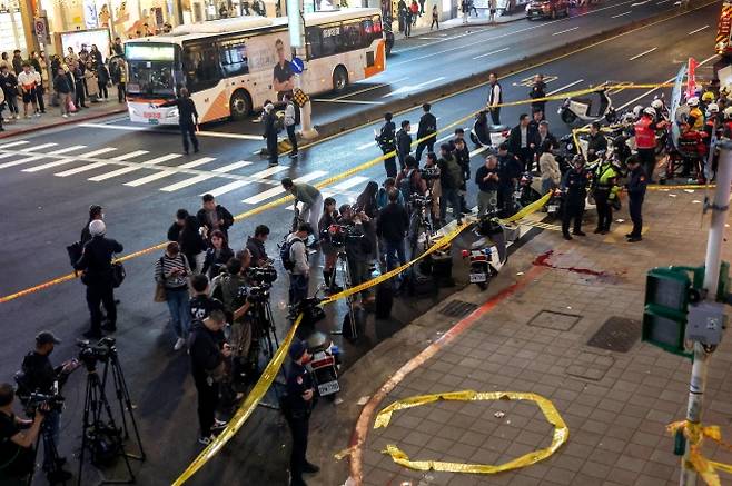 19일(현지시간) 대만 타이베이 도심 한복판에서 연막탄과 흉기를 이용한 무차별 공격이 벌어져 용의자를 포함해 4명이 숨지고 11명이 다쳤다. 사진은 이날 사건이 벌어진 중산역 인근 에슬레이트 백화점 앞을 통제 중인 경찰과 취재 중인 언론. 2025.12.19 타이베이 로이터 연합뉴스