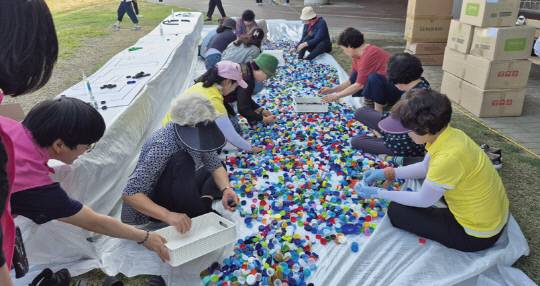 돗자리영화제에서 가장동 주민자치회 회원들이 병뚜껑 활용 체험 프로그램에 참여하고 있는 모습. 서구 제공