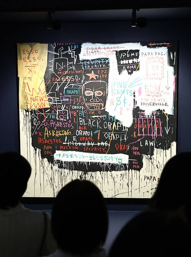 The viewers look at″Museum Security (Broadway Meltdown)″ (1983) by Jean-Michel Basquiat at his solo show "Signs: Connecting Past and Future″ which runs through Jan. 31 of next year at the Dongdaemun Design Plaza (DDP) in central Seoul. [JOONGANG ILBO]