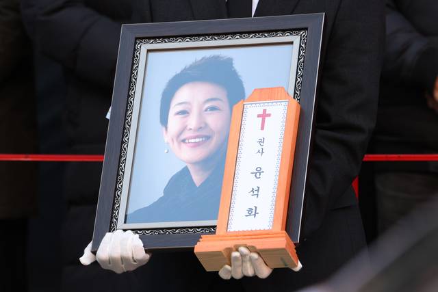 21일 서울 종로구 한예극장 앞에서 열린 배우 윤석화의 노제에서 유가족이 영정을 들고 있다. 연합뉴스