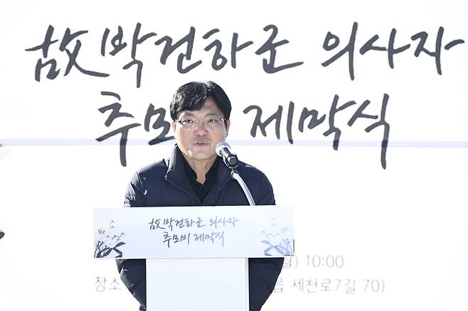 22일 대구 달성군 다사세천늪근린공원에서 열린 고 박건하 군 추모비 제막식에서 유가족 대표인 아버지가 단상에 올라 답사를 하고 있다. 아들의 이름이 새겨진 추모비 앞에서 그는 짧지만 절제된 말로 감사와 다짐을 전했고, 행사장은 깊은 침묵과 눈물로 가득 찼다.<달성군 제공>