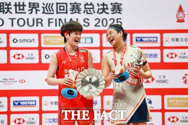 96분의 접전을 펼친 중국의 왕즈이(왼쪽)와 트로피를 들고 밝게 웃고 있는 안세영./신화.뉴시스