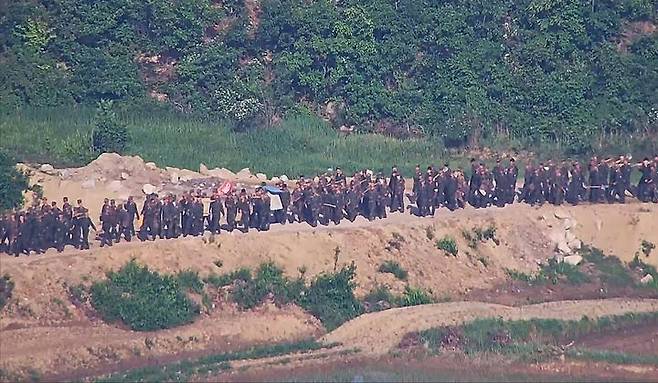 [서울=뉴시스] 합동참모본부는 18일 오전 8시 30분께 중부전선 비무장지대 내에서 작업하던 북한군 수십명이 군사분계선(MDL)을 침범해 우리 군의 경고방송 및 경고사격에 북상했다고 밝혔다.합참 관계자는 북한이 4월경부터 다수병력을 투입해 경계력 보강 일환 불모지 조성, 지뢰매설, 전술도로 보강, 대전차 방벽으로 보이는 미상 구조물 설치 등 다양한 형태의 작업을 진행 중이라고 전했다. 사진은 대규모 병력을 투입한 북한군 모습. (사진=합동참모본부 제공) 2024.06.18. photo@newsis.com *재판매 및 DB 금지