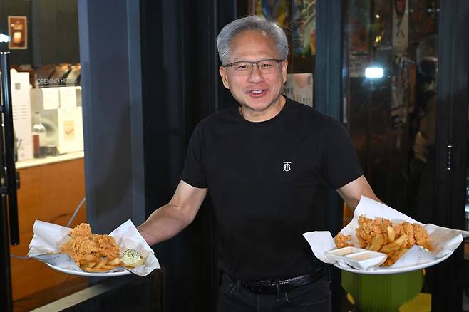 젠슨 황 엔비디아 최고경영자(CEO)가 30일 오후 서울 강남구 삼성역 인근 깐부치킨 매장에서 이재용 삼성그룹 회장, 정의선 현대차그룹 회장과 치킨 회동 중 매장 밖으로 나와 시민들에게 치킨을 나눠주고 있다.(공동취재) 2025.10.30/뉴스1 ⓒ News1