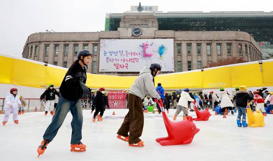 Tourists enjoy their time on an ice skating rink set up in front of the Seoul City Hall building in central Seoul on Dec. 20, 2025. [NEWS1]
