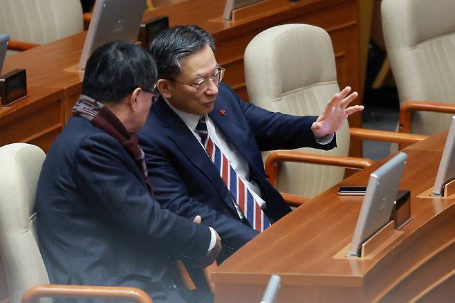 정성호 법무부 장관이 23일 국회에서 열린 12월 임시국회 본회의에서 이헌승 국민의힘 의원과 대화하고 있다. ⓒ 연합뉴스