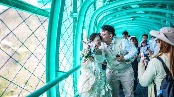 지난 9월 중국 구이저우성 화장 대협곡 대교에서 한 신혼부부가 사진 촬영을 하고 있다. 신화=연합뉴스