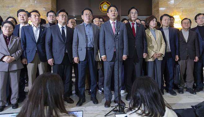 장동혁 국민의힘 대표(마이크 앞)가 23일 내국회 본회의장에서 24시간 동안 홀로 무제한 토론을 진행한 뒤 발언하고 있다. [사진 출처 = 연합뉴스]