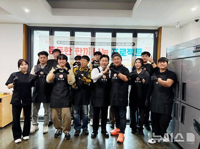 [수원=뉴시스]  '든든한 한 끼 나눔 프로젝트'참가자들이 기념사진을 찍고 있다. (사진=㈜깡에프앤비 제공) 2025.12.24.photo@newsis.com